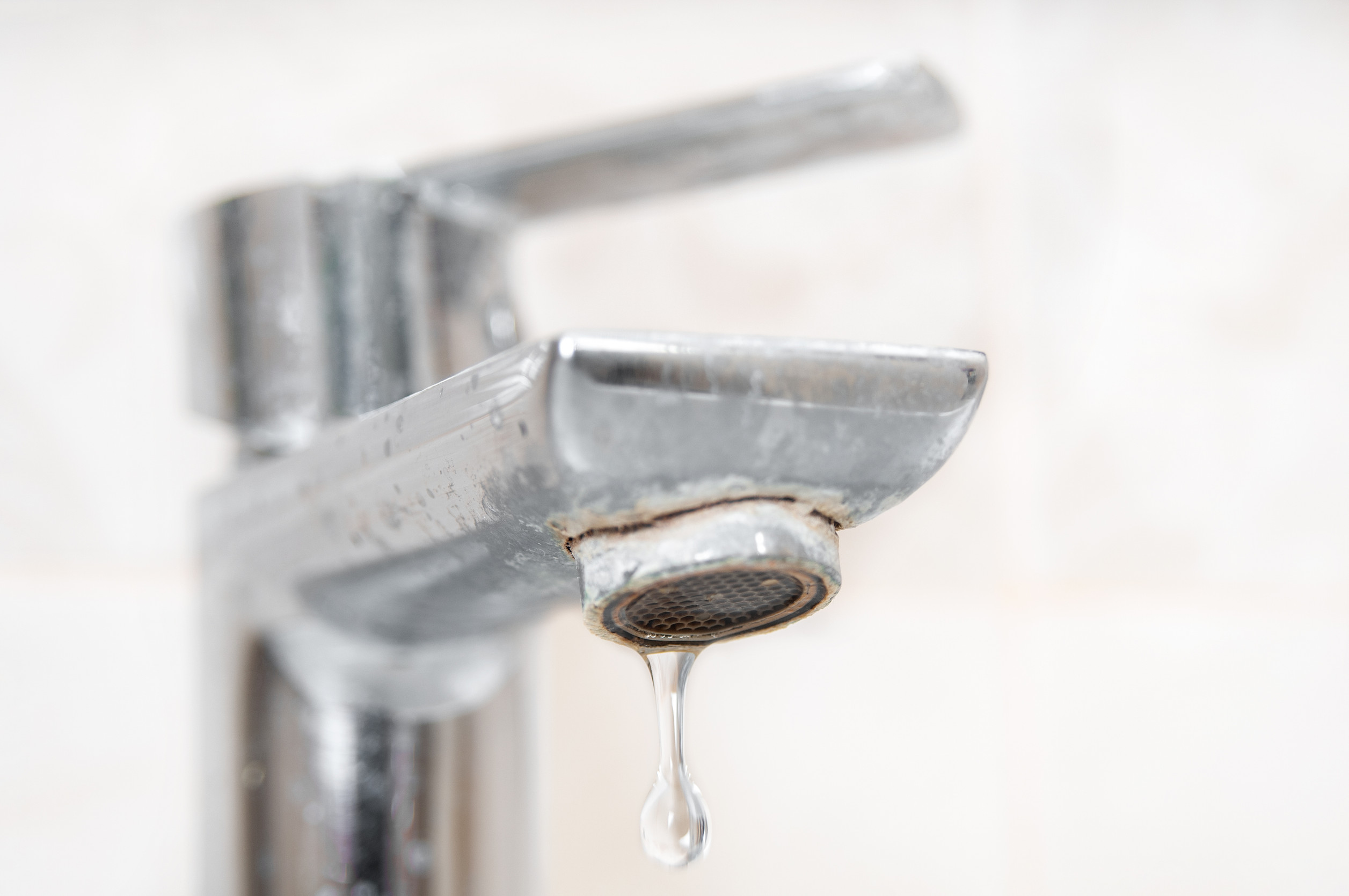 Calcium and scale buildup on a faucet caused by hard water