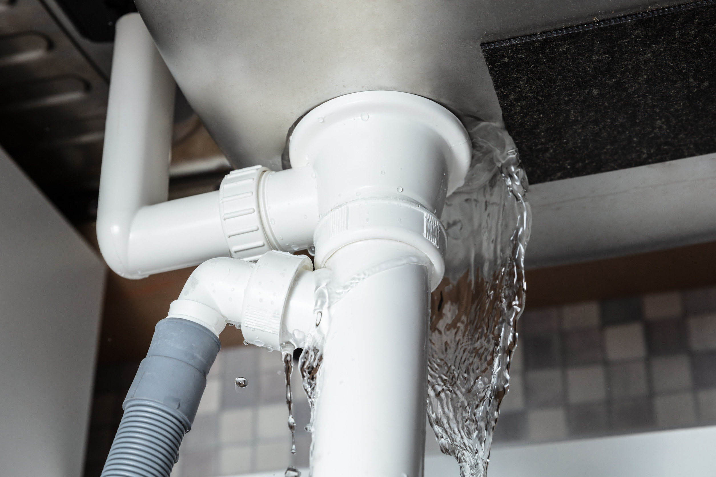 Water gushing from a failed drain trap during a plumbing emergency